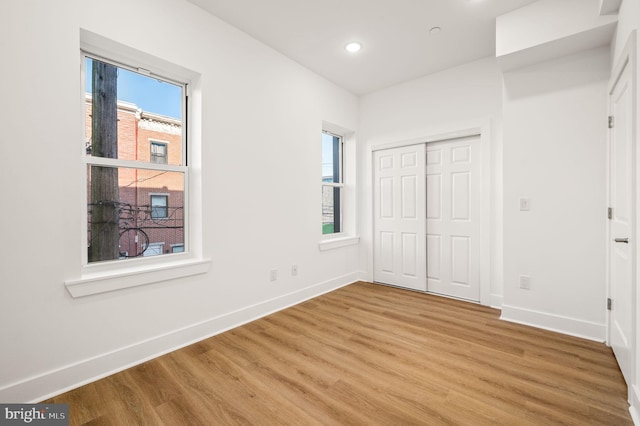 unfurnished bedroom featuring light hardwood / wood-style flooring and a closet