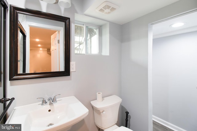 bathroom with sink, wood-type flooring, and toilet