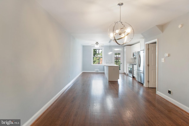 interior space featuring ceiling fan with notable chandelier, dark hardwood / wood-style flooring, and sink