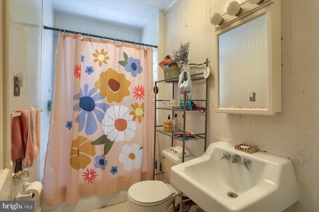 bathroom featuring sink, a shower with shower curtain, tile patterned flooring, toilet, and tile walls