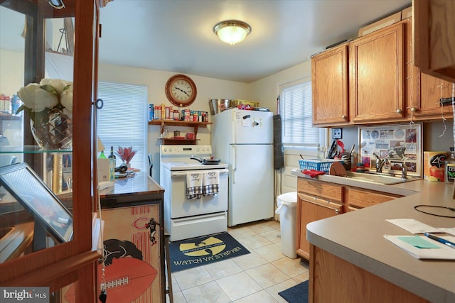 kitchen featuring sink, light tile patterned floors, and white appliances