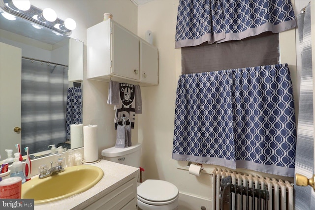 bathroom with vanity, toilet, and radiator