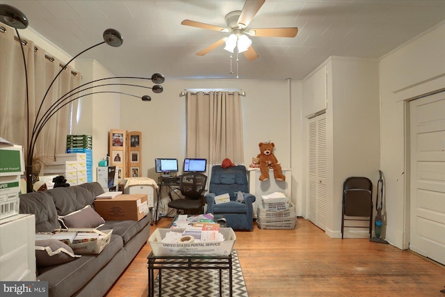 living room with ceiling fan, wood-type flooring, and crown molding