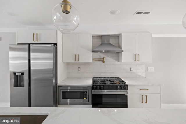 kitchen with white cabinets, stainless steel appliances, and wall chimney range hood