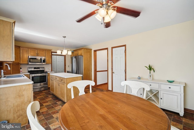 dining space with ceiling fan with notable chandelier and sink