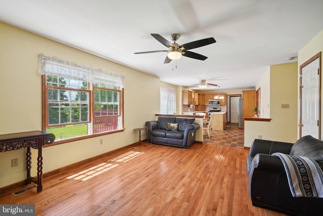 living room with ceiling fan and light hardwood / wood-style flooring