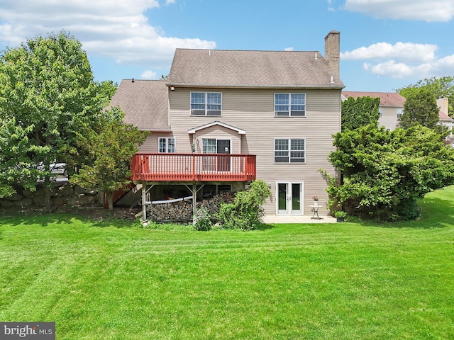 back of house with a deck, a yard, and french doors