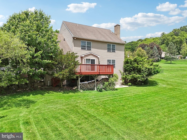 rear view of house with a yard and a wooden deck