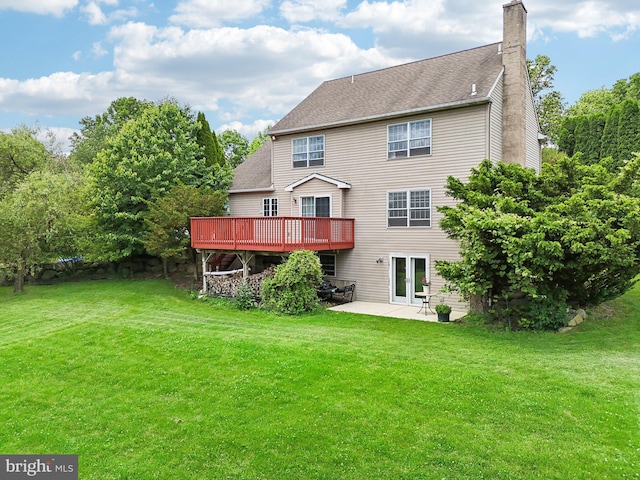 back of property featuring a yard, a patio, and a wooden deck