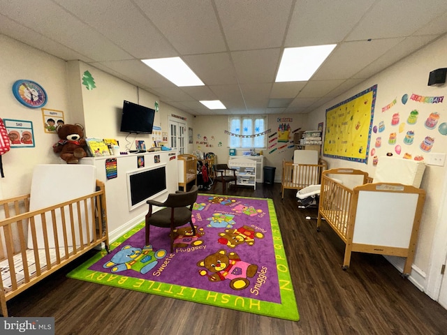 recreation room with a drop ceiling and dark hardwood / wood-style floors