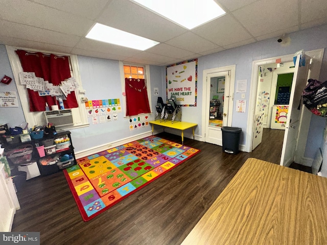 playroom featuring a paneled ceiling, cooling unit, and dark wood-type flooring