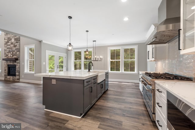 kitchen with appliances with stainless steel finishes, sink, wall chimney range hood, white cabinets, and dark hardwood / wood-style floors