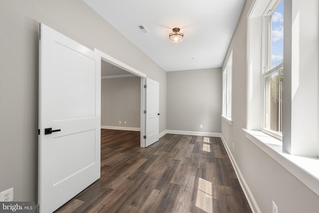 unfurnished room with plenty of natural light and dark wood-type flooring