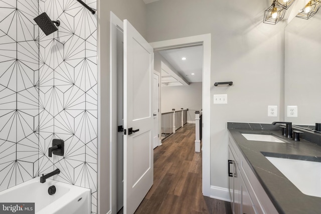 bathroom with hardwood / wood-style floors, vanity, tile walls, and bathing tub / shower combination