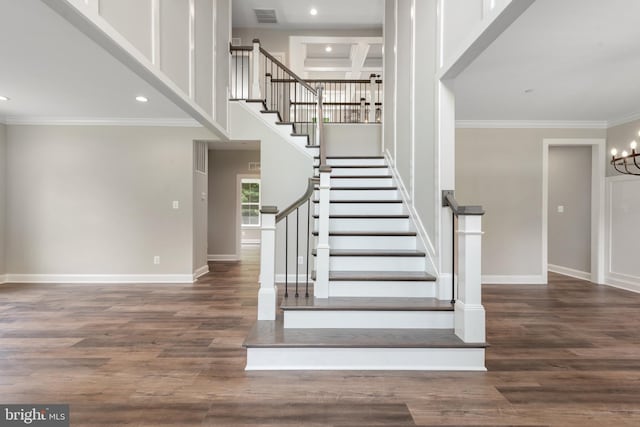 stairway with hardwood / wood-style floors, an inviting chandelier, and ornamental molding