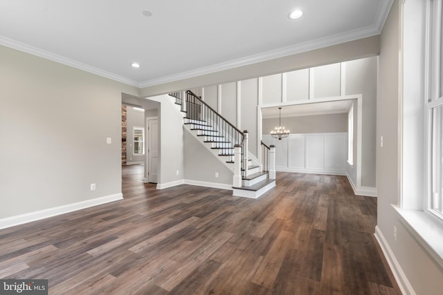 unfurnished living room featuring a chandelier, dark hardwood / wood-style floors, and crown molding