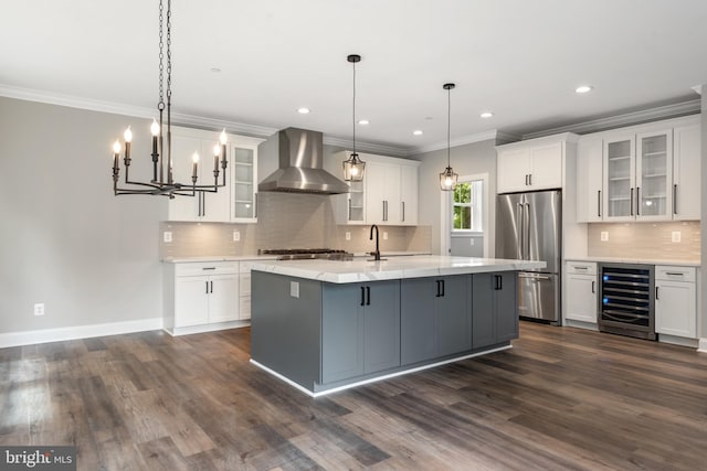 kitchen featuring wall chimney exhaust hood, wine cooler, decorative light fixtures, white cabinets, and appliances with stainless steel finishes