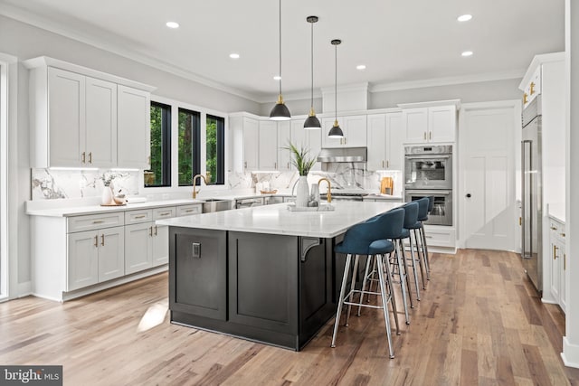 kitchen featuring white cabinetry, ornamental molding, and stainless steel appliances