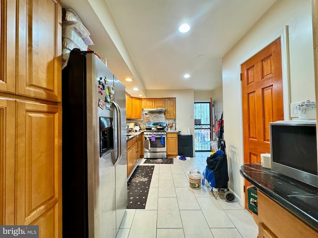 kitchen featuring decorative backsplash, light tile patterned floors, and stainless steel appliances