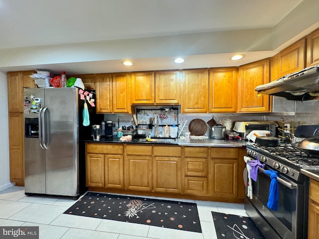 kitchen featuring decorative backsplash, light tile patterned floors, stainless steel appliances, and extractor fan