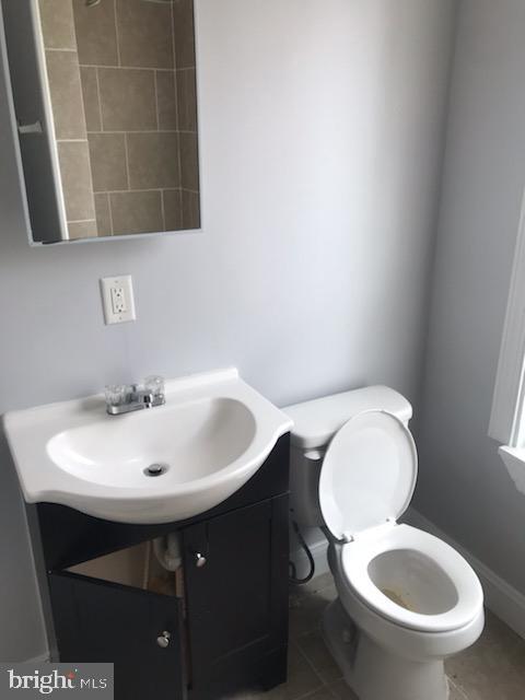 bathroom featuring toilet, vanity, and tile patterned floors