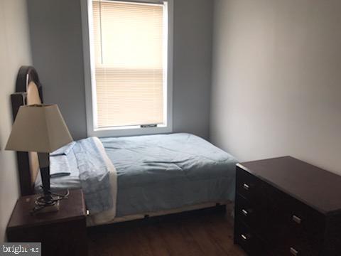 bedroom with dark hardwood / wood-style flooring