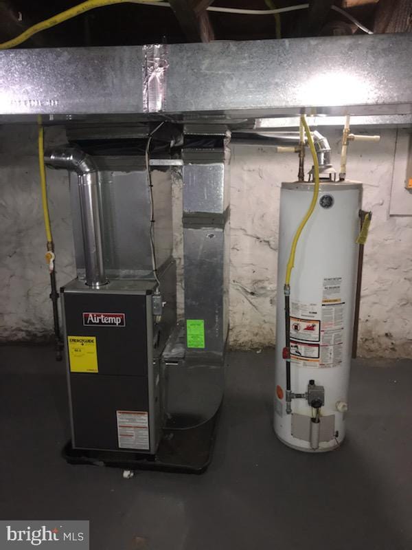 utility room featuring heating unit and water heater