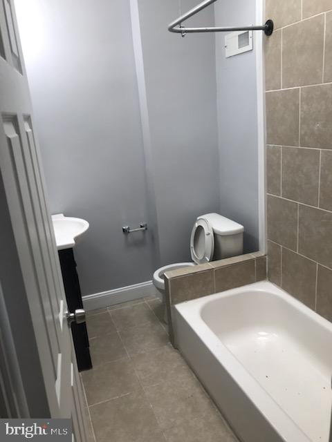 full bathroom with vanity, tiled shower / bath combo, and toilet