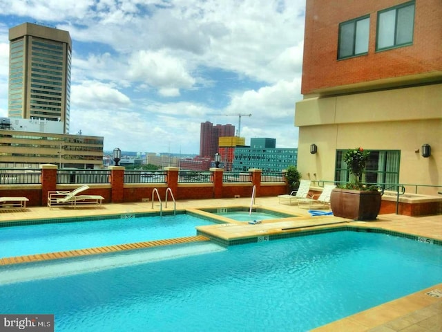 view of pool with a hot tub