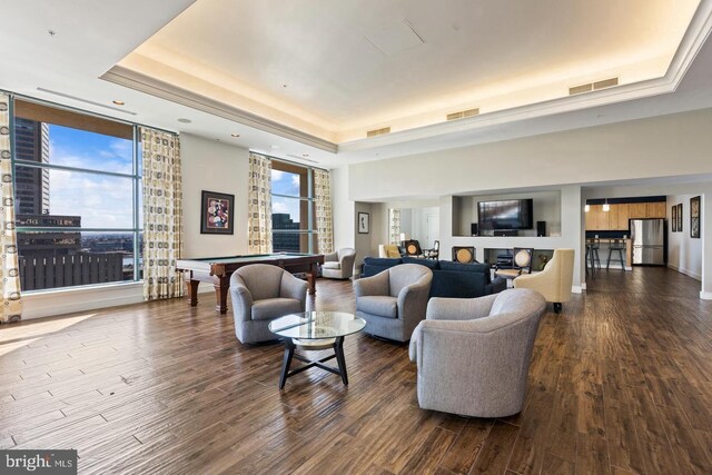 living room with a tray ceiling and dark hardwood / wood-style flooring