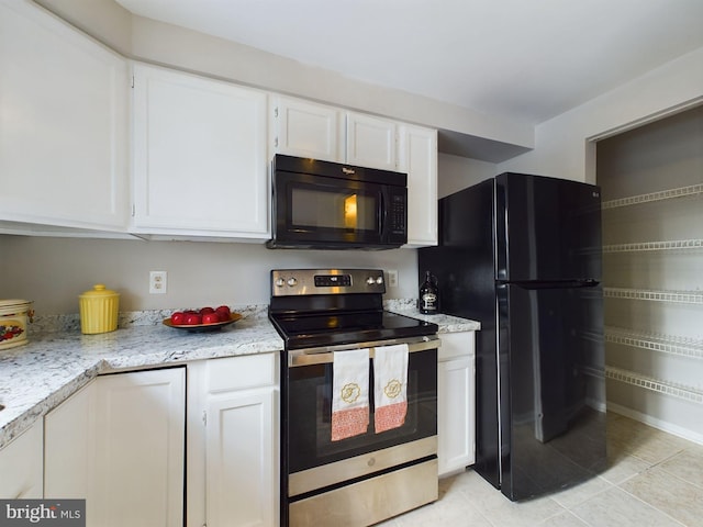 kitchen featuring light tile patterned floors, white cabinets, and black appliances