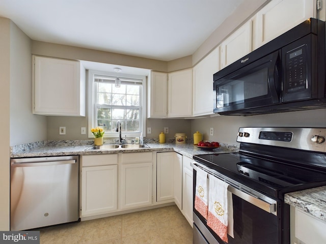 kitchen featuring light stone countertops, appliances with stainless steel finishes, white cabinetry, and sink