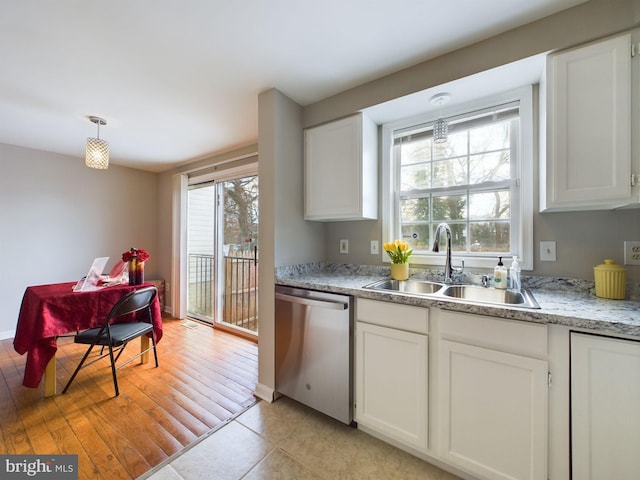 kitchen with dishwasher, pendant lighting, light tile patterned flooring, sink, and white cabinetry