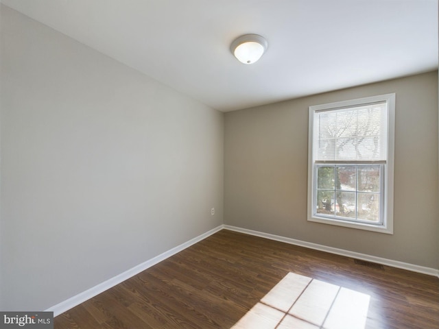 unfurnished room with dark wood-type flooring