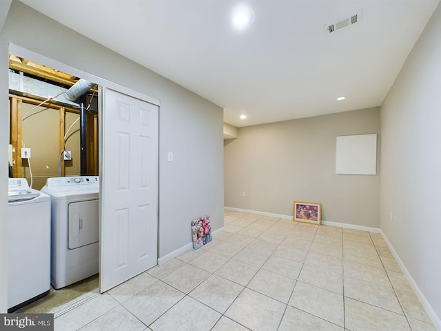 laundry area with washer and dryer and light tile patterned floors