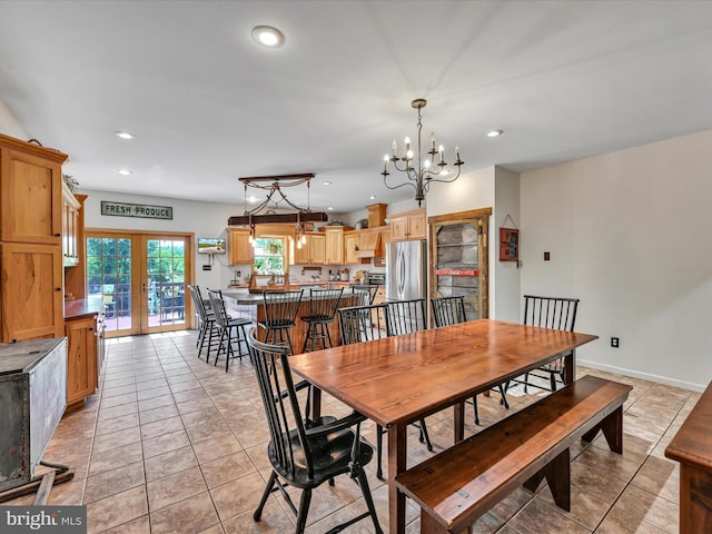 dining space featuring french doors, light tile patterned floors, and a notable chandelier