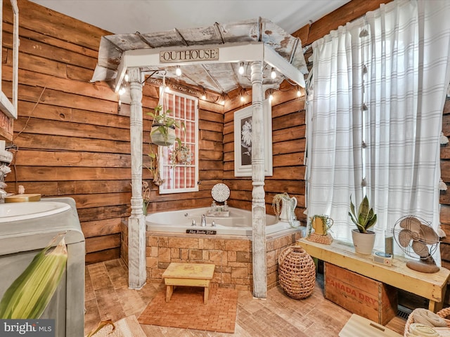 bathroom featuring a tub to relax in, vanity, decorative columns, and log walls