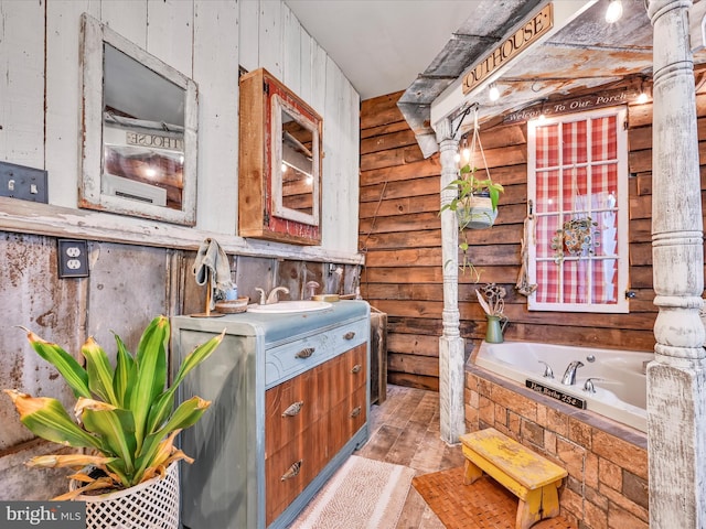 bathroom with tiled tub and vanity