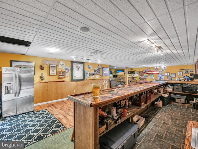 interior space with dark hardwood / wood-style flooring and wooden walls