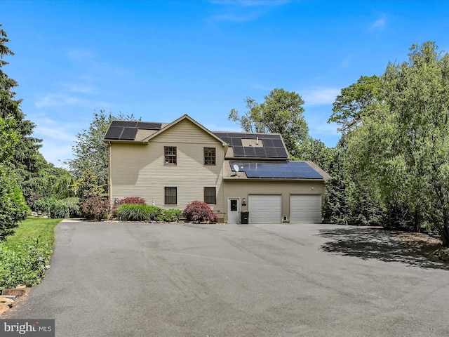 front of property featuring solar panels and a garage