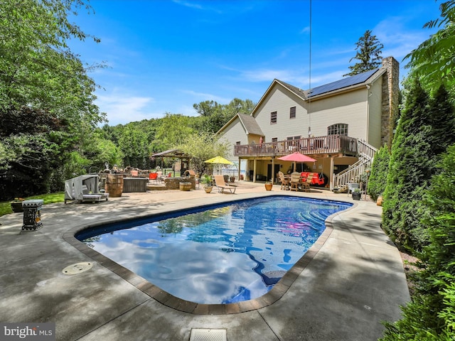 view of swimming pool featuring area for grilling, a patio, and a wooden deck