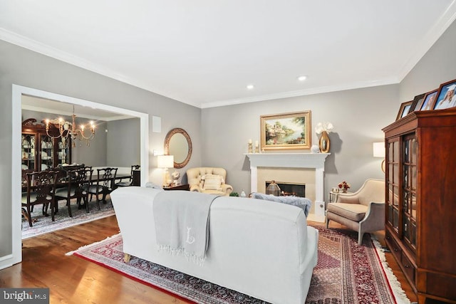 living room with a notable chandelier, crown molding, and dark wood-type flooring