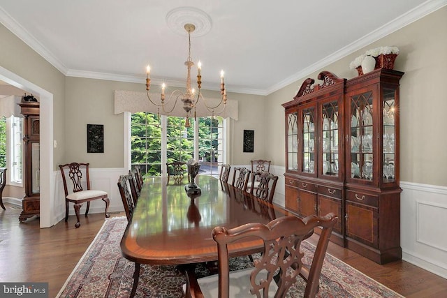 dining area featuring dark hardwood / wood-style flooring, crown molding, and plenty of natural light