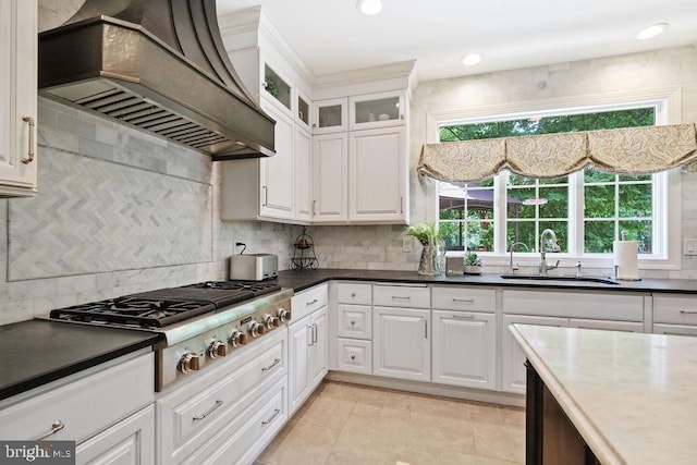 kitchen with premium range hood, white cabinetry, sink, and stainless steel gas stovetop