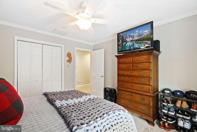 carpeted bedroom with ceiling fan, ornamental molding, and a closet