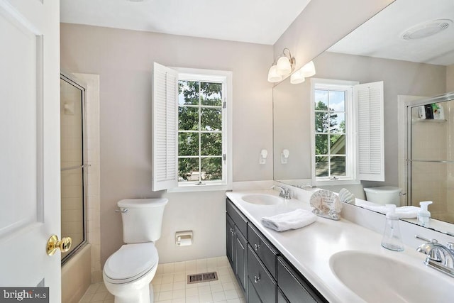 full bathroom featuring shower / bath combination with glass door, vanity, tile patterned floors, and a healthy amount of sunlight