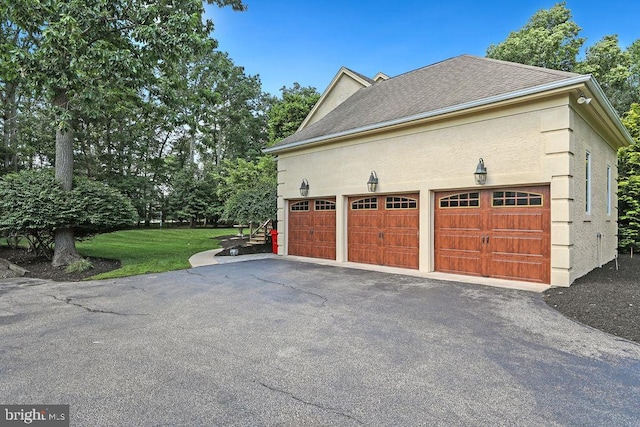 view of side of property featuring a lawn and a garage