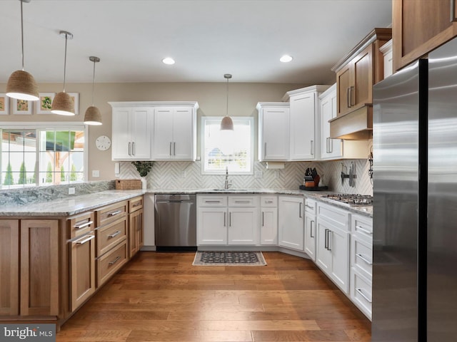 kitchen with pendant lighting, stainless steel appliances, and white cabinetry