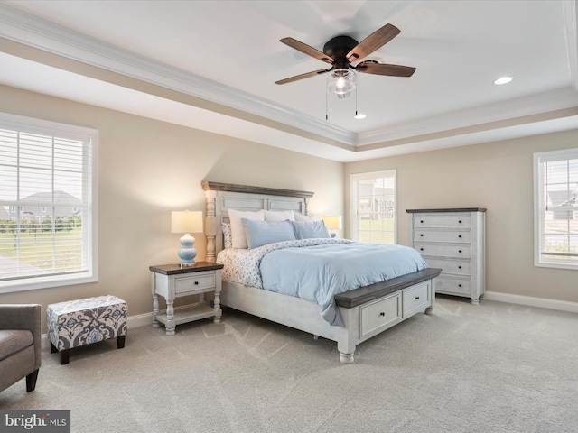 bedroom featuring light carpet, a tray ceiling, ceiling fan, and crown molding