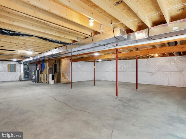 basement featuring heating unit, electric panel, and water heater